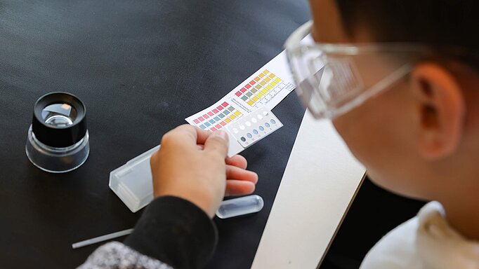 Ein Schüler vergleicht im Rahmen des "Lab in a drop"-Programms Testergebnisse anhand eines Farbschemas.