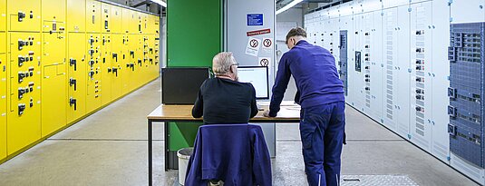 Im Kontrollraum überwachen zwei Kollegen die Betriebstechnik.