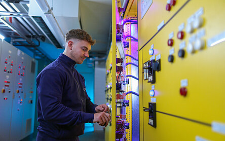 Ein Mitarbeiter inspiziert einen Schaltschrank