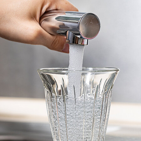 Leitungswasser wird in ein Trinkglas gefüllt