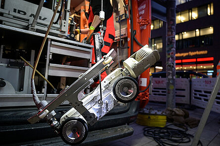 Ein roboterhaftes kleines Fahrzeug hängt an einem Seil und wird ins Siel eingelassen.