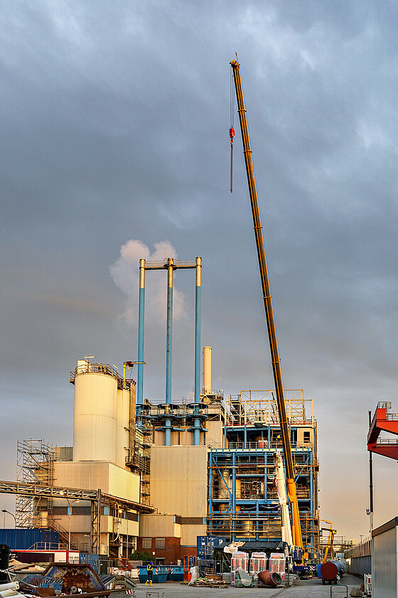 Ein Kran steht auf der Baustelle auf dem Klärwerk, bereit Anlagenteile in die VERA einzuheben.